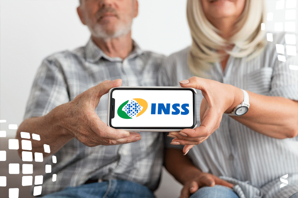 Casal de idosos segurando celular com logo do INSS na tela