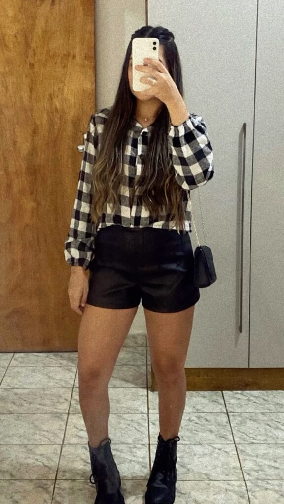 Look junino casual com camisa xadrez preta e branca, shorts e coturno
