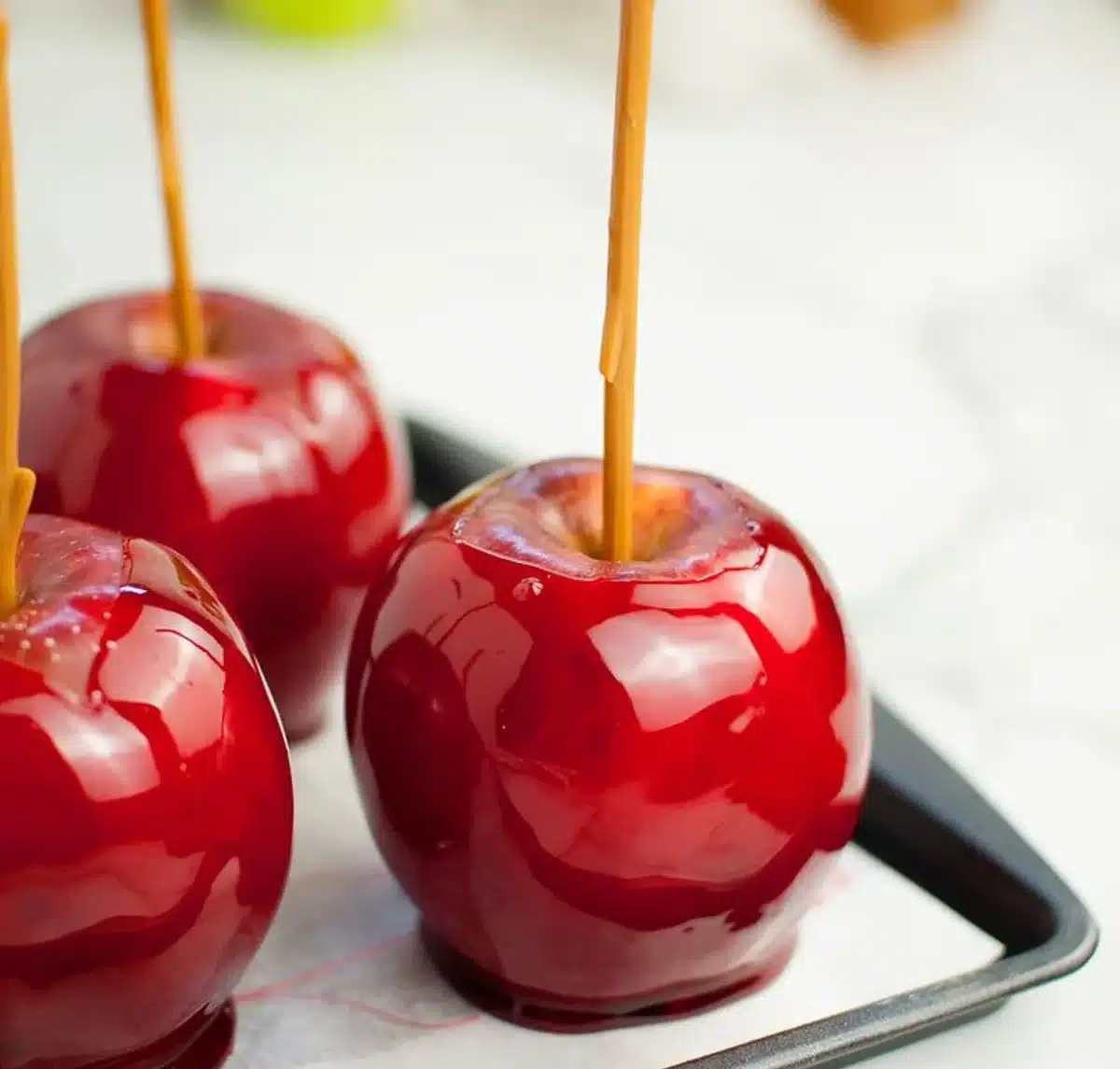 A maçã do amor brilhante e vermelha com calda brilhante, pronta para ser saboreada.