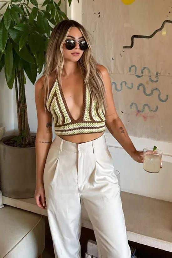 Top de crochê combinado com calça de alfaiataria branca em look moderno de verão