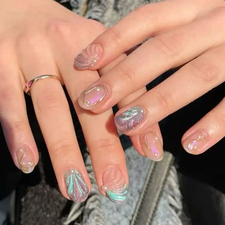 nhas com design de conchas e pérolas em tons iridescentes, criando um toque sofisticado e elegante com efeitos metálicos e texturizados.
