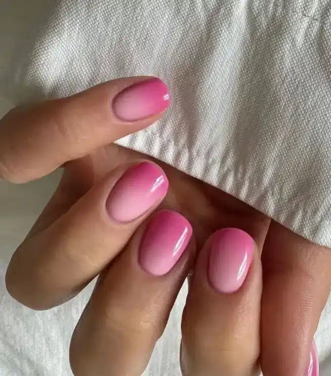 Unhas com efeito ombré, em tons de rosa claro e nude, criando um visual sofisticado.