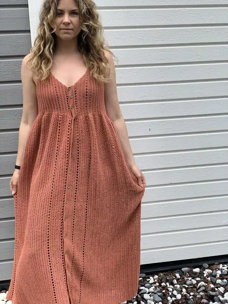 Vestido longo de crochê terracota com botões frontais, ideal para looks elegantes e modernos.