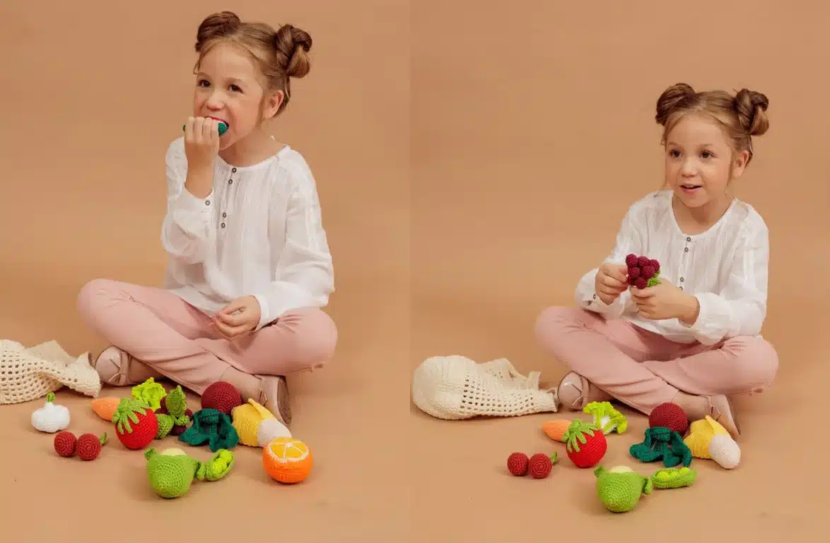 Criança brincando com frutas de amigurumi, explorando cores, formas e texturas.