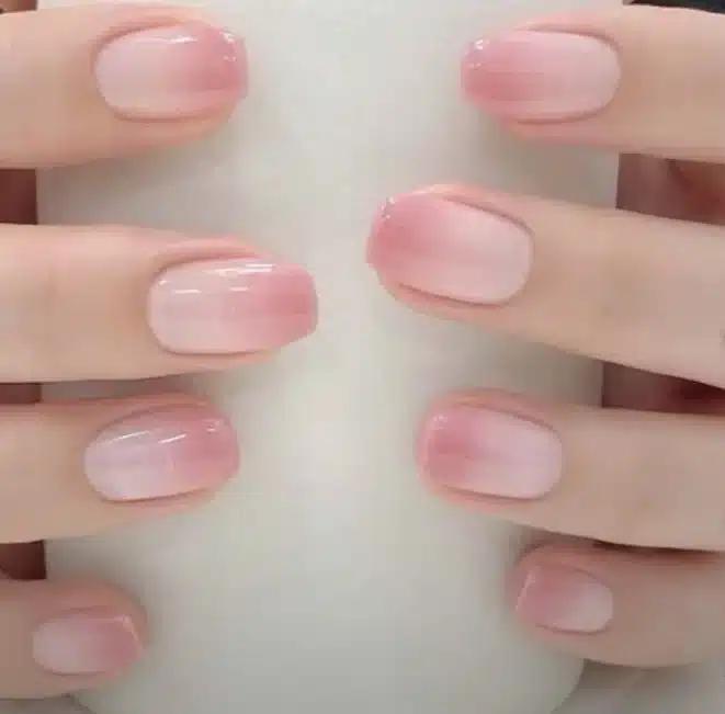 Unhas com Baby Boomer, transição suave entre rosa claro e branco, estilo de manicure francesa.