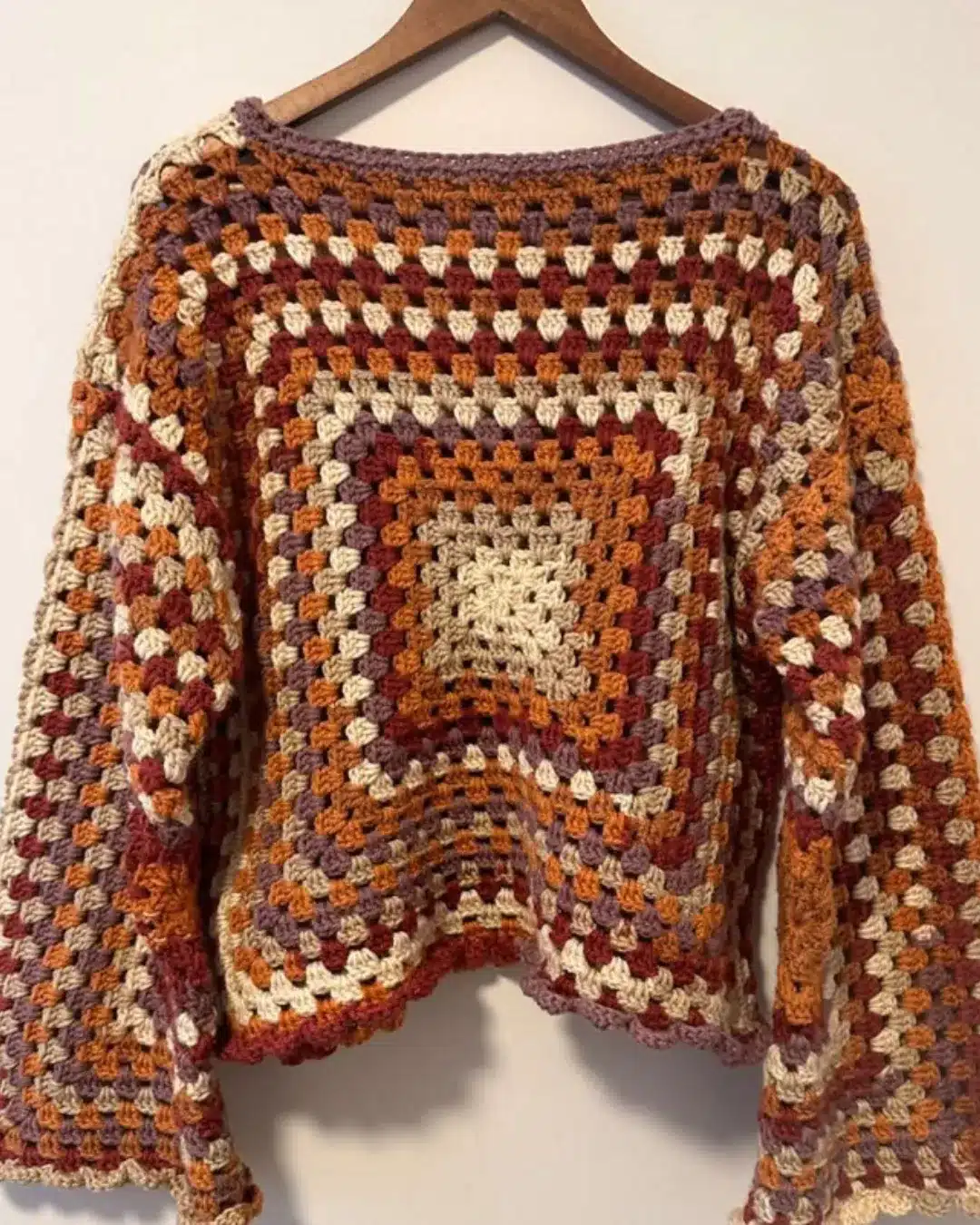 Blusa de crochê com pontos granny square em tons terrosos e acabamento artesanal.