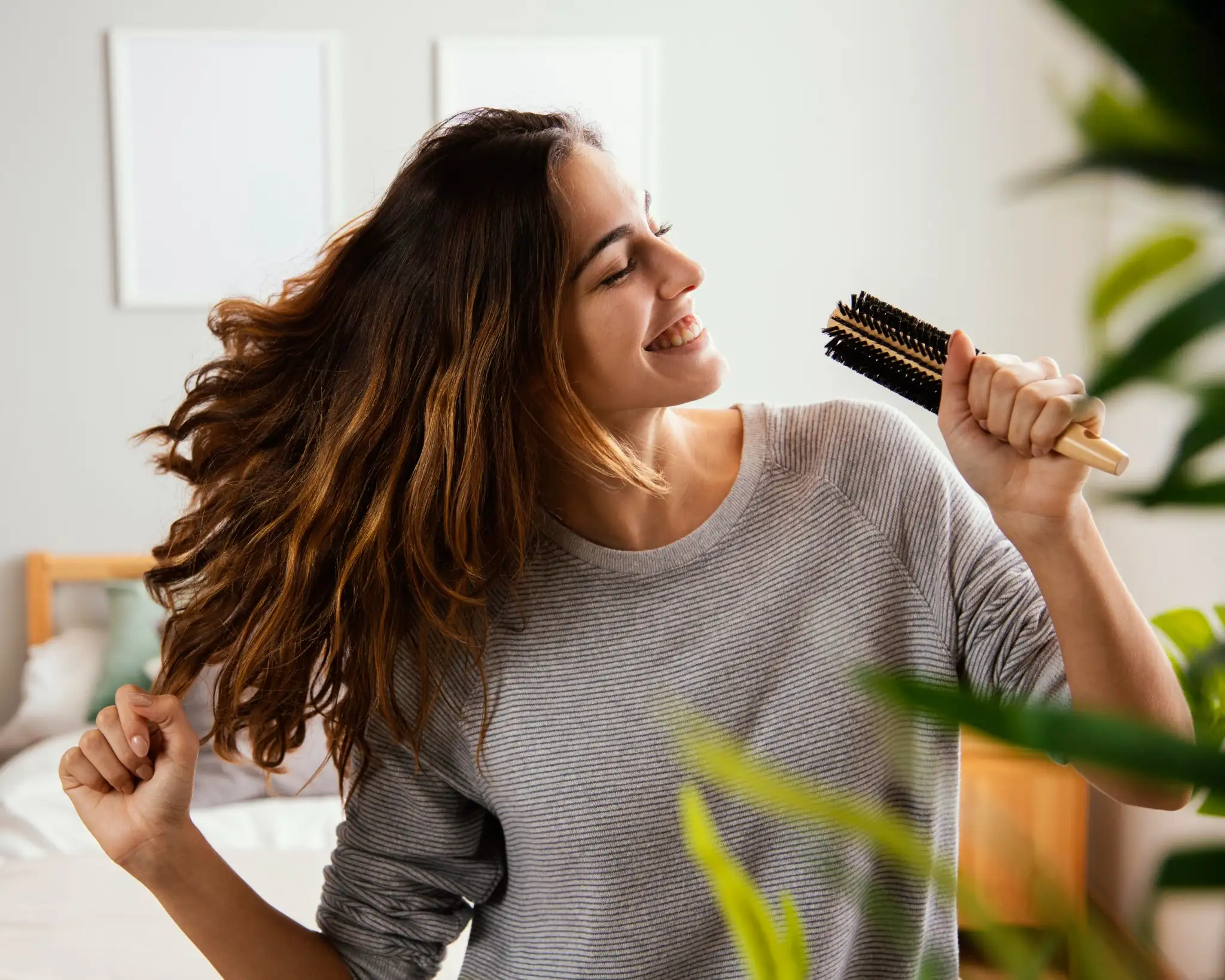 Mulher sorrindo com cabelo solto e brilhoso após tratamento capilar