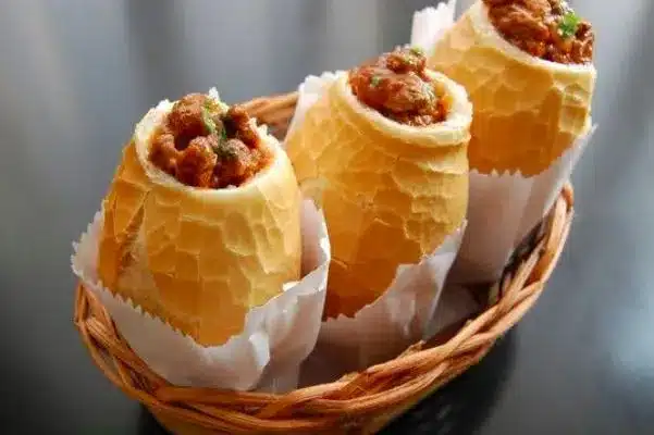 Buraco quente: pão francês recheado com carne moída, ovo e azeitonas, servido em uma cesta.