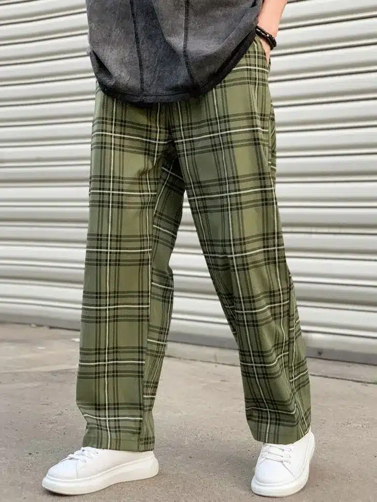 Homem usando calça xadrez verde com tênis branco, em um estilo casual.