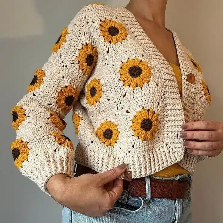 Casaco de crochê bege com flores amarelas estilo girassol, feito à mão.
