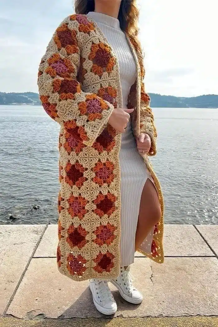 Casaco longo de crochê com quadrados coloridos em tons terrosos.