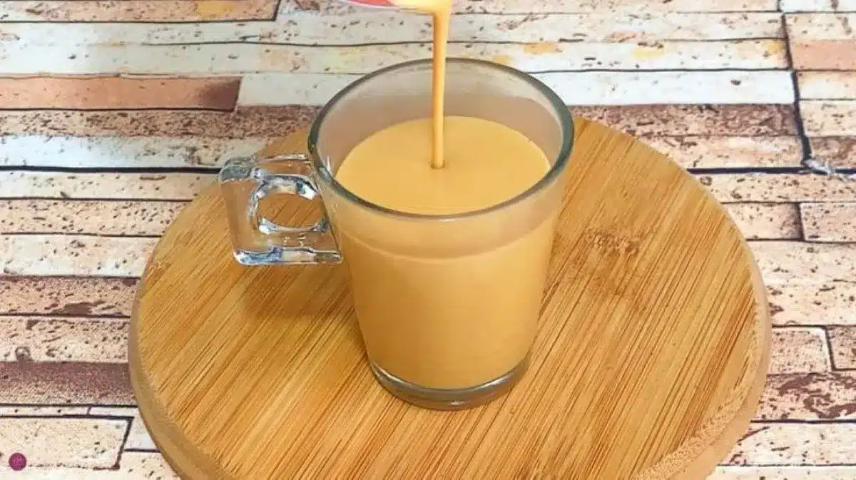 Chá de amendoim cremoso servido em copo transparente, perfeito para festas juninas.