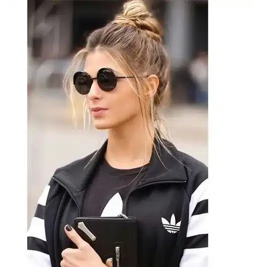 Mulher com coque despojado, visual casual e moderno.