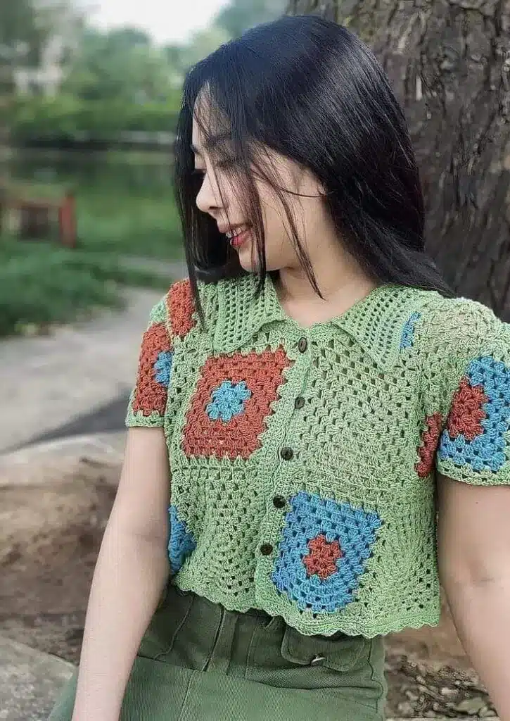 Mulher usando camiseta cropped de crochê verde com detalhes coloridos