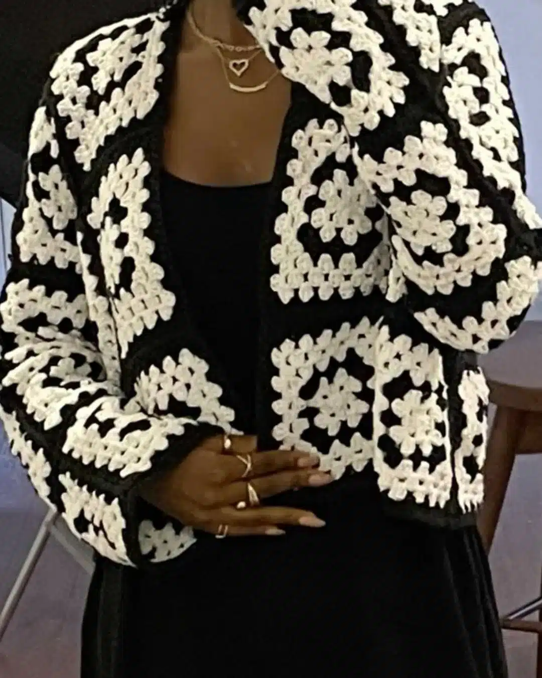 Cardigã de crochê preto e branco com quadrados geométricos.