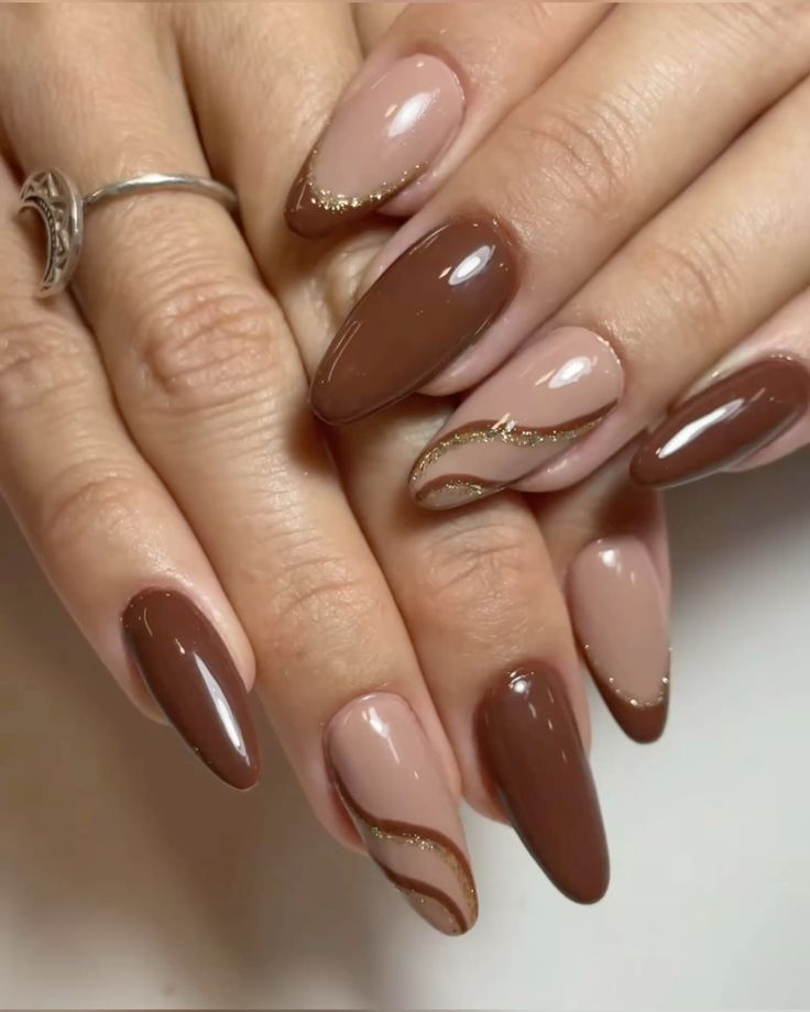 Unhas decoradas na cor mocha mousse com detalhes dourados