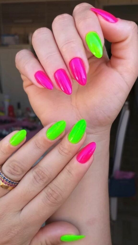 Unhas curvas com esmalte neon verde e rosa