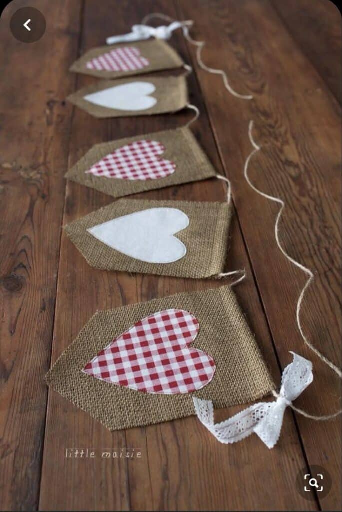 Bandeirinhas de juta decoradas com corações em tecido estampado para festa junina.