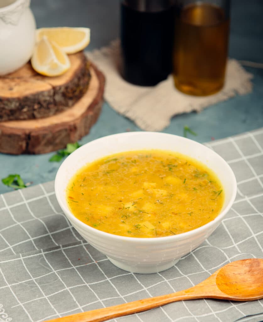 Caldo de mandioca servido em tigela branca com ervas frescas