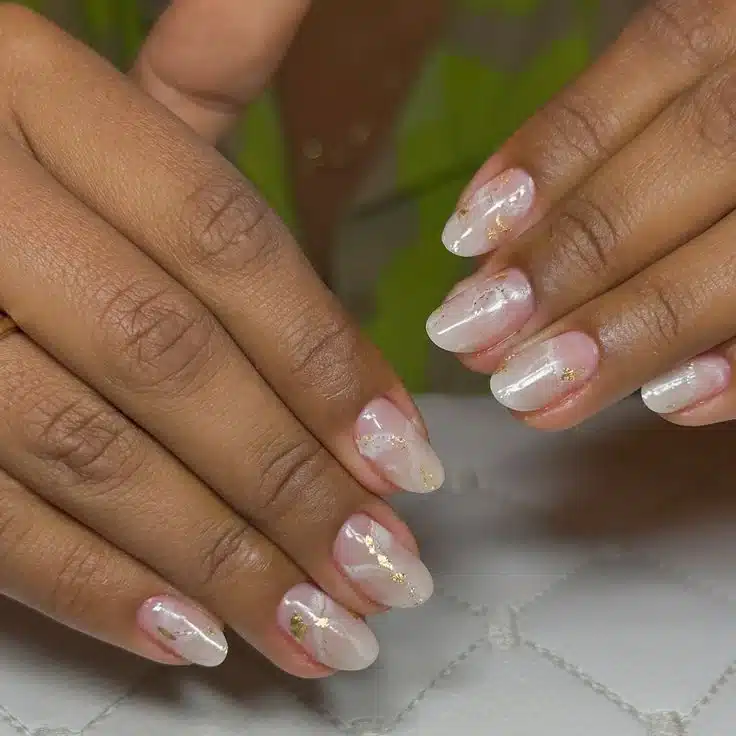 Unhas decoradas com efeito marmorizado branco e dourado