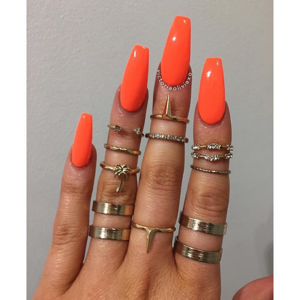 Unhas pintadas com esmalte laranja vibrante, cor ousada e energética, perfeita para qualquer estação.