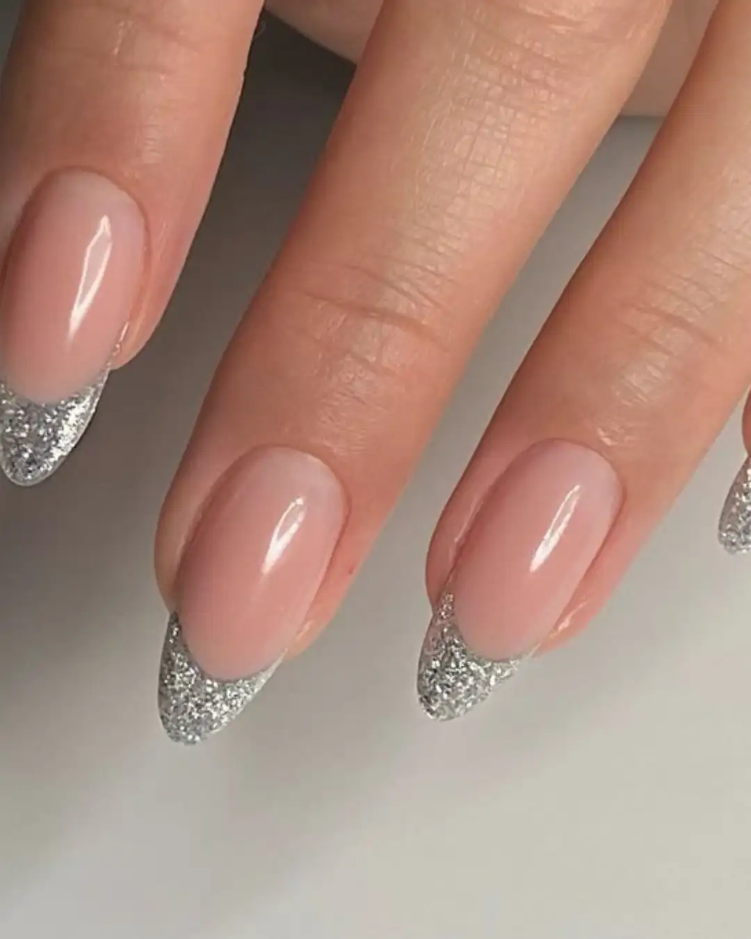Unhas com francesinha prateada em glitter e formato amendoado