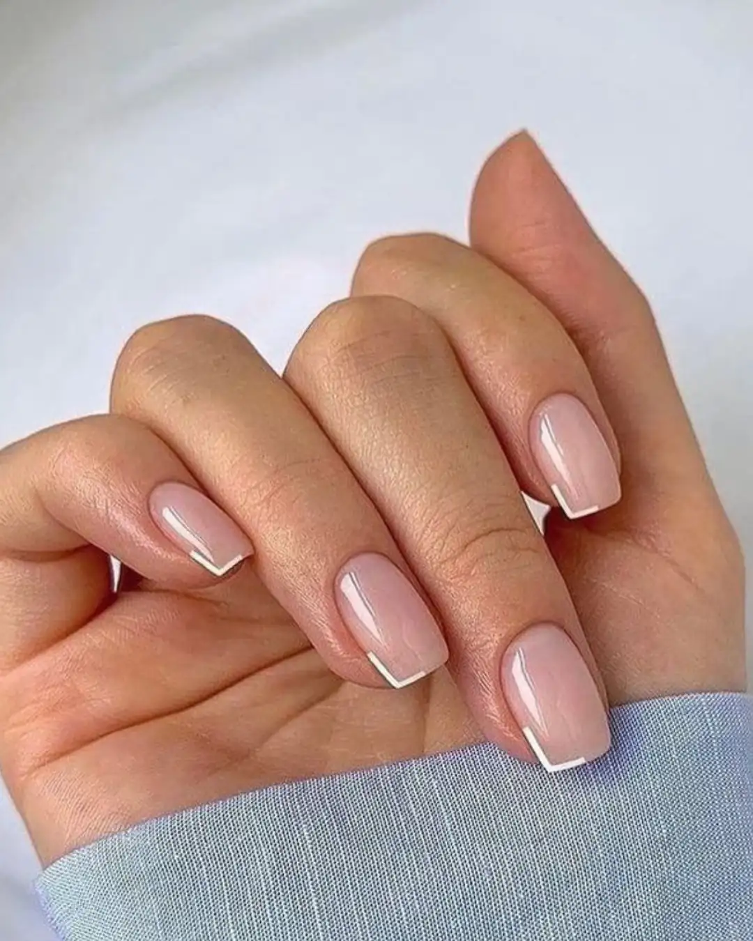 Unhas curtas com francesinha geométrica branca em formato quadrado