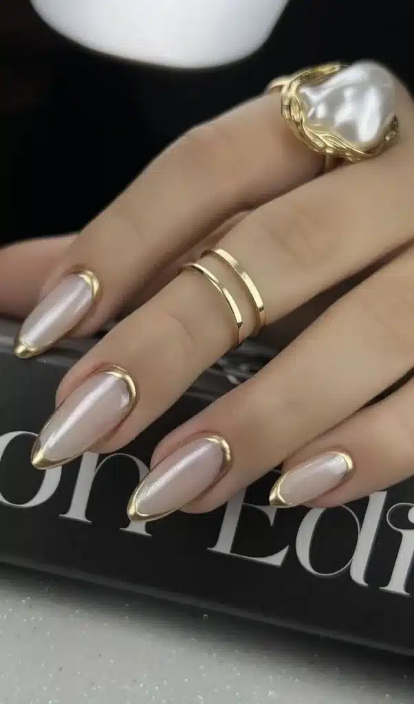 Unhas de francesinha moderna com ponta dourada, trazendo um toque de sofisticação ao visual.