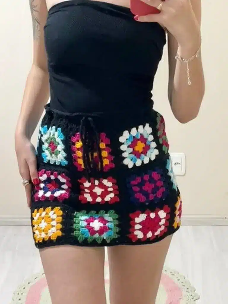 Mulher usando saia de crochê colorida em visual casual e moderno