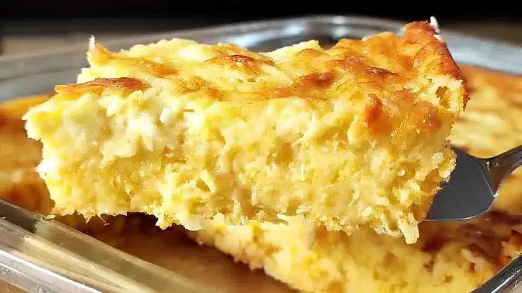 Fatia dourada e cremosa de pamonha assada salgada com crosta crocante e recheio macio.