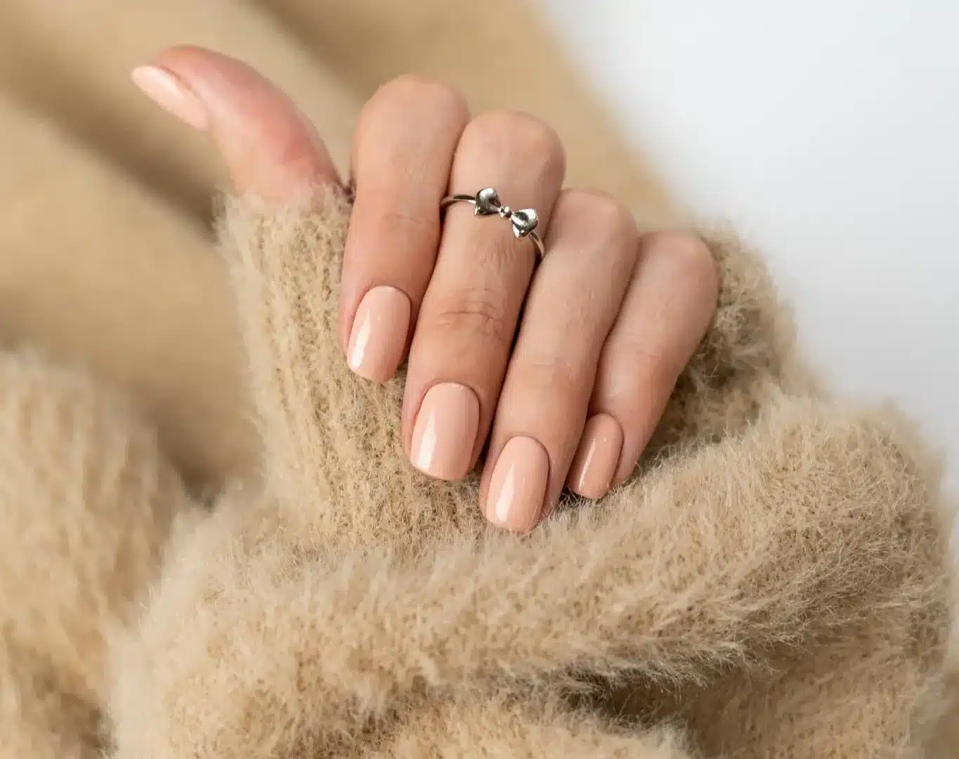 Unhas bege perfeitas em uma manicure de inverno