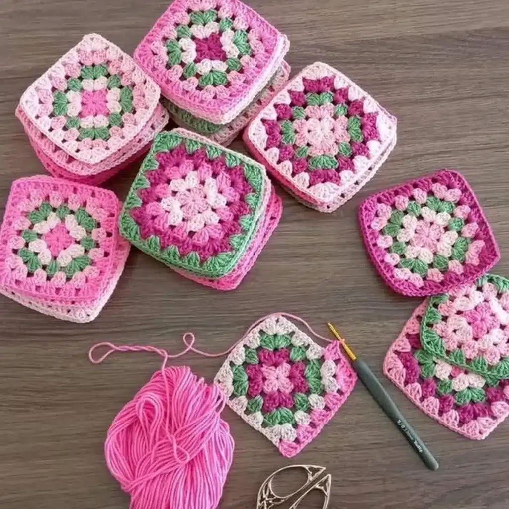 Quadradinhos de crochê em tons de rosa e verde prontos para serem usados em peças artesanais