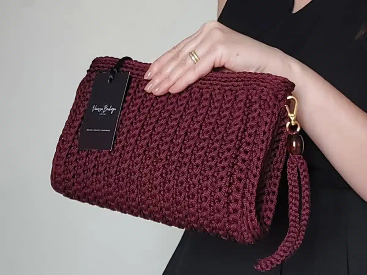 Bolsa de crochê bordô com tag de marca, estilo sofisticado e elegante.