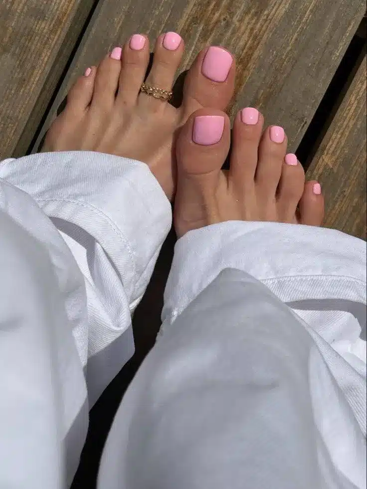 Unhas dos pés com esmalte rosa claro, destacando o visual delicado e bem cuidado.