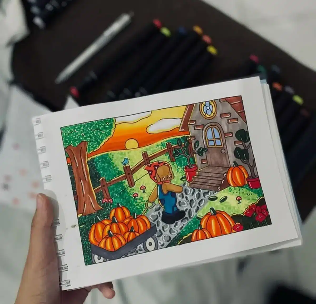 Desenho colorido de cenário com abóbora feito com canetinhas, ilustrando técnicas de pintura sem manchas.