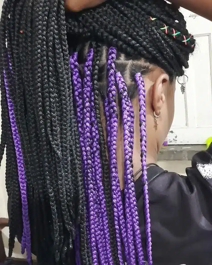 Tranças com detalhes em crochê na cor roxa, em processo de aplicação.