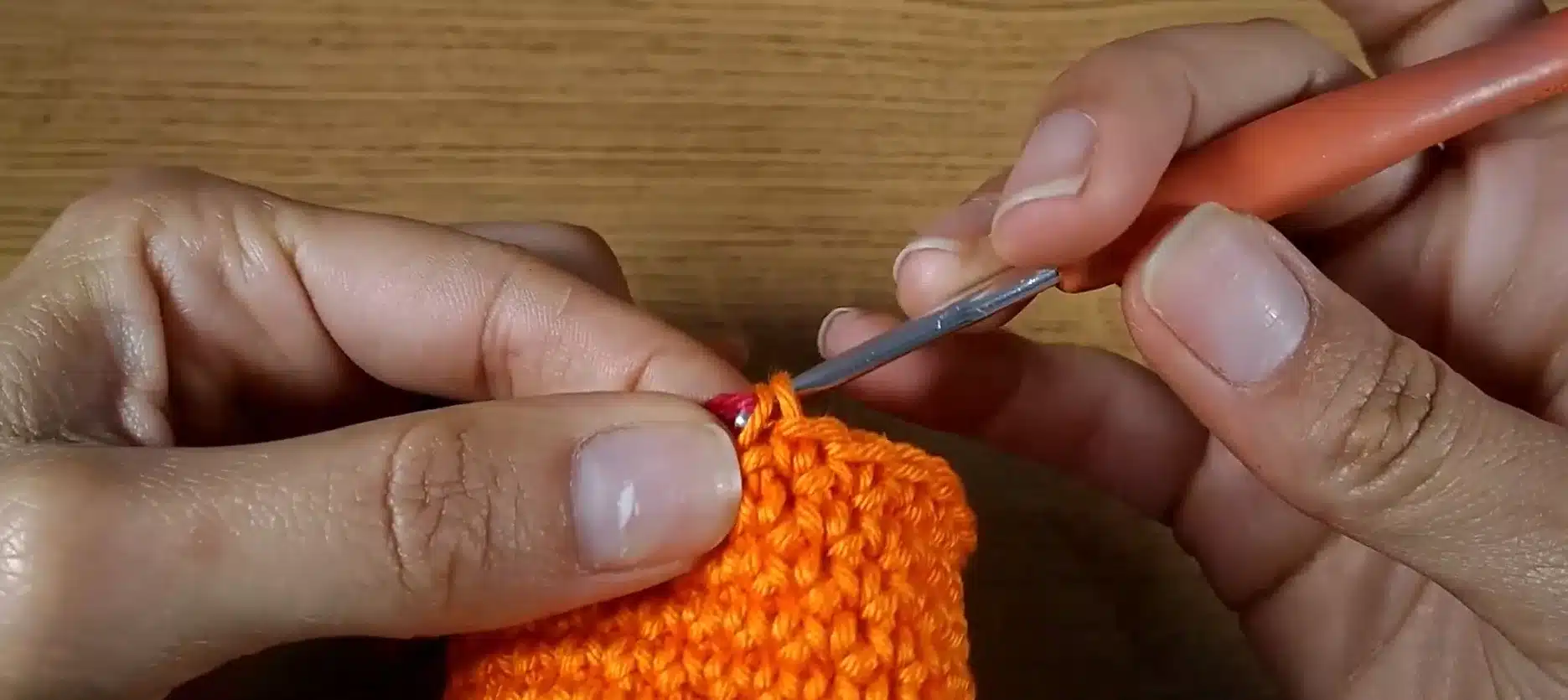Início do trabalho em crochê com troca de cores e fios, mostrando como ajustar o fio inicial de forma precisa.