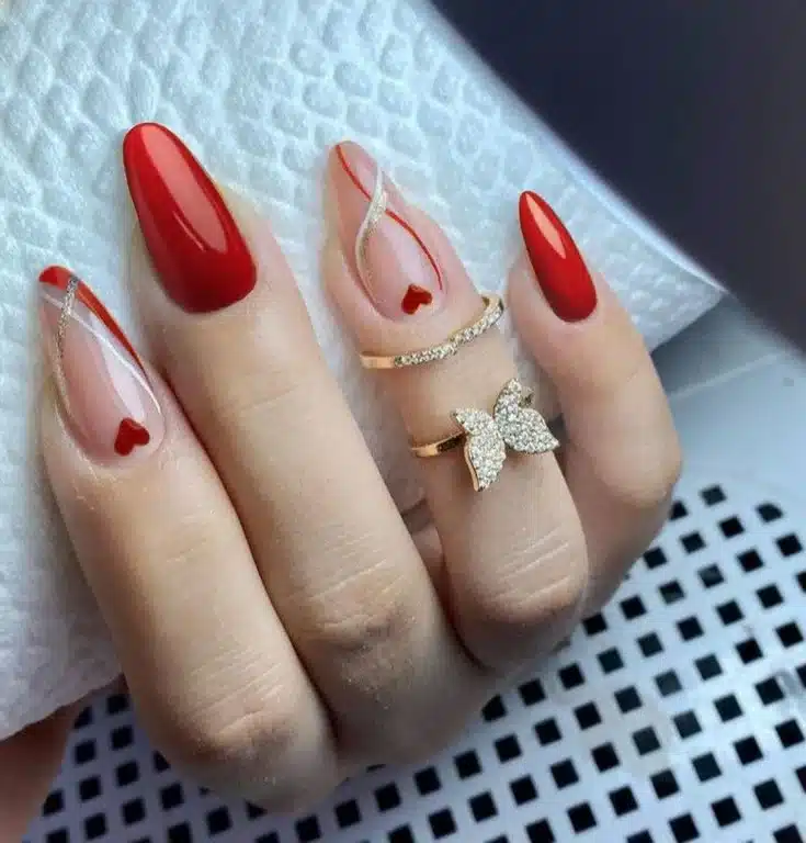  Unhas decoradas com corações e detalhes em dourado, trazendo um toque artístico e delicado.