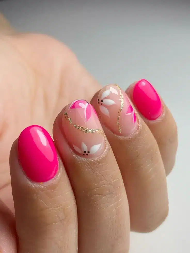 Unhas decoradas com flores brancas e esmalte rosa vibrante
