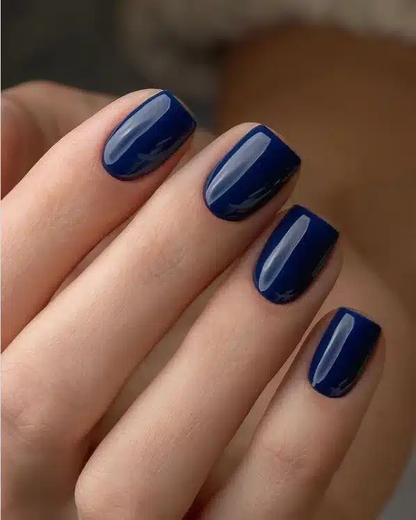 Unhas curtas pintadas com esmalte azul-marinho brilhante para festas juninas