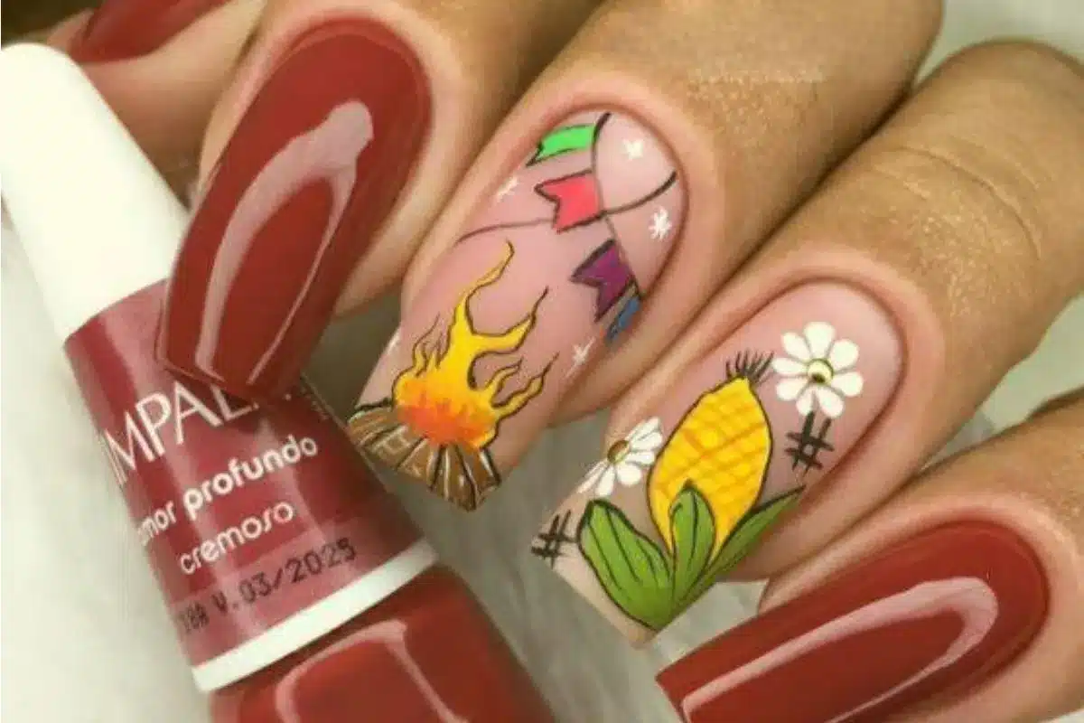 Unhas decoradas para festa junina com fogueira, bandeirinhas e espiga de milho.
