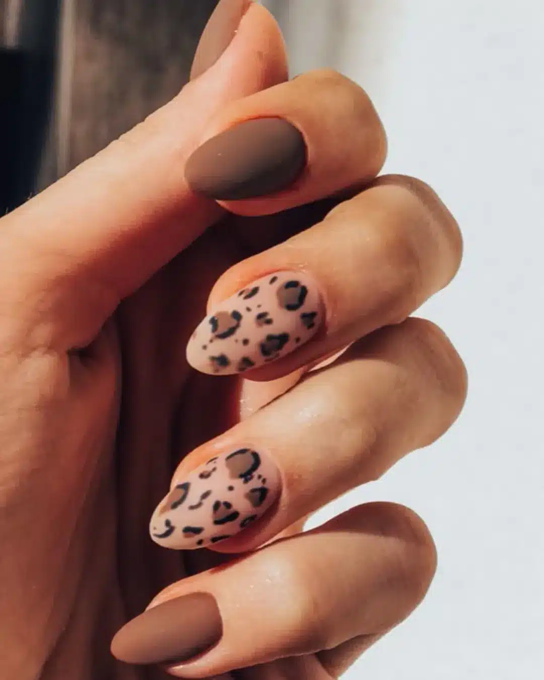Unhas decoradas com acabamento fosco e estampa animal print estilo oncinha.