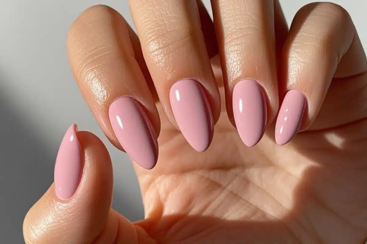 Unhas postiças em tom rosa claro com acabamento natural e formato amendoado.