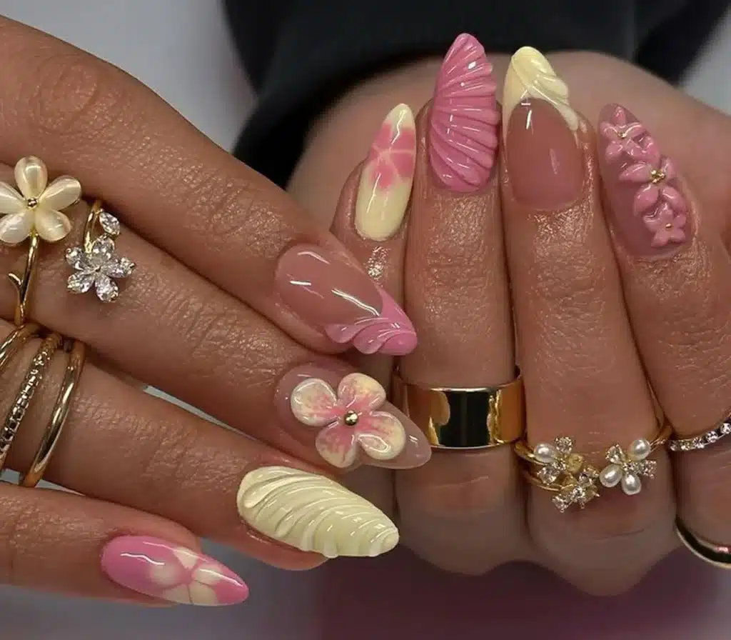 Unhas em 3D: Arte delicada com flores e texturas, cores suaves de rosa e amarelo.