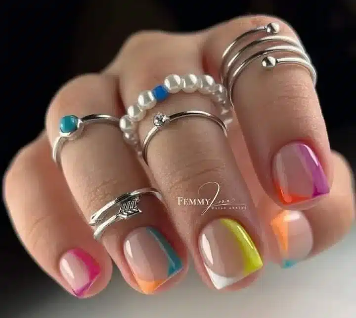Unhas coloridas e artísticas com design geométrico e cores vibrantes, expressando estilo único e personalidade.