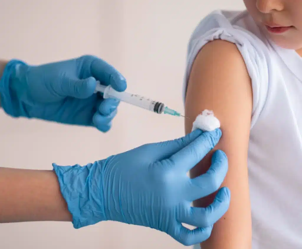 Profissional de saúde aplicando vacina em criança para prevenção de doenças respiratórias graves.