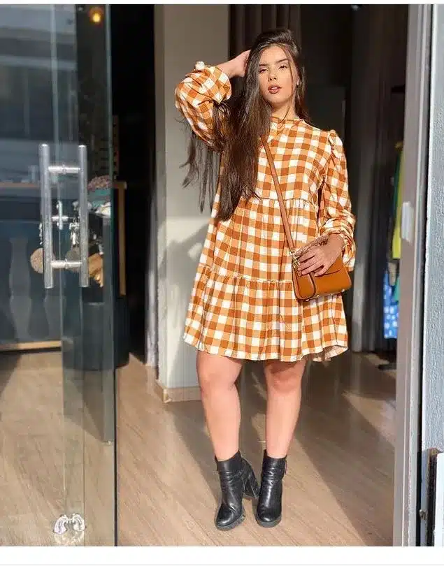 Mulher com vestido xadrez laranja e branco