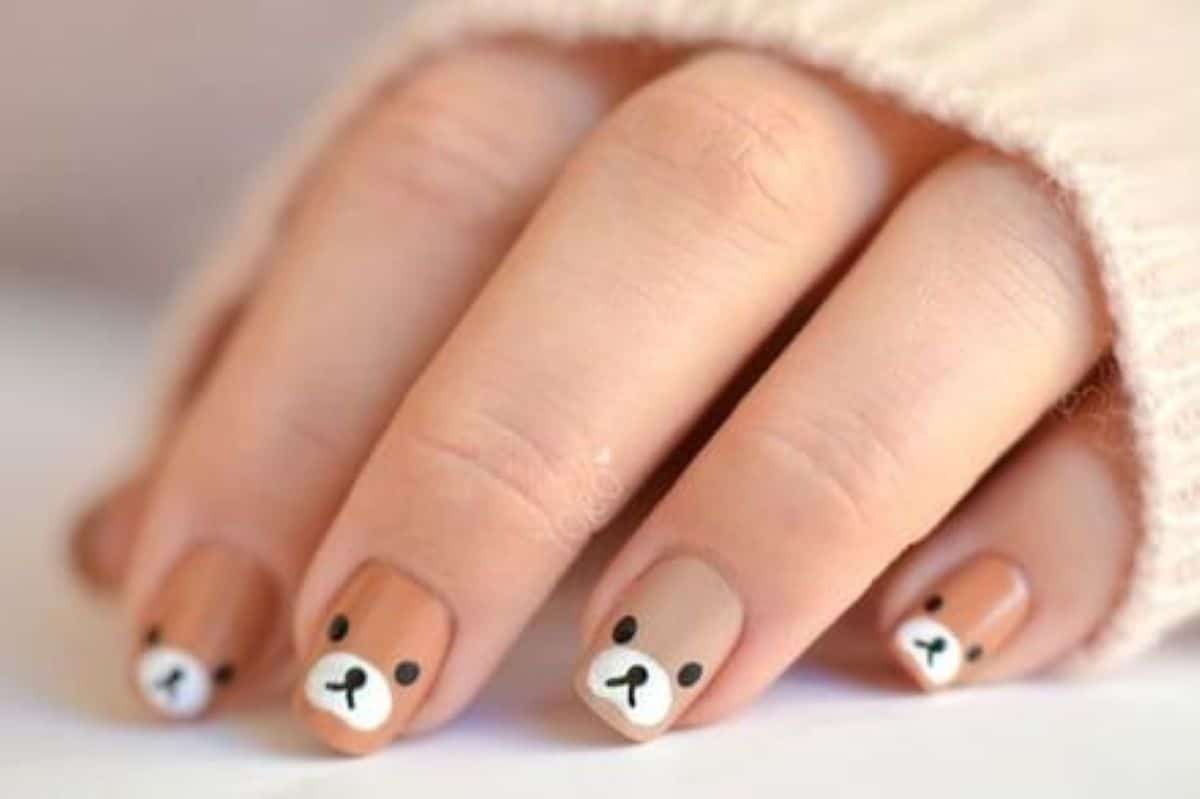 Unhas kawaii decoradas com desenhos fofos de rostos de ursos, trazendo um toque adorável para suas mãos.