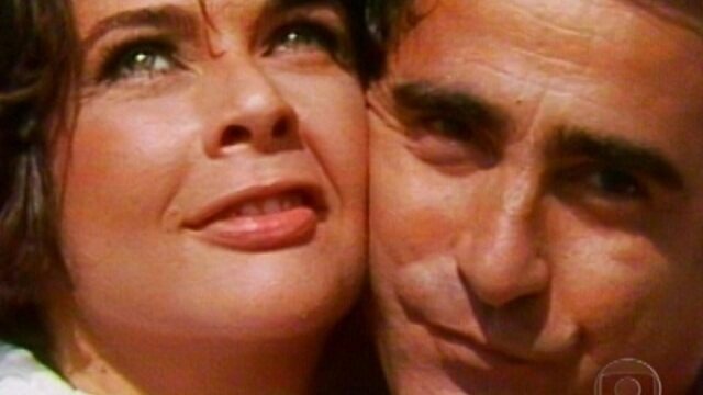 Cena romântica da novela Te Contei? com casal protagonista em close.