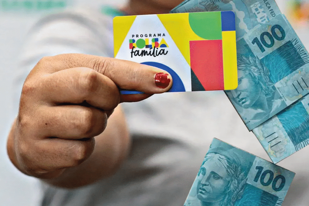 Mulher segurando o cartão do novo Bolsa Família com notas de 100 reais ao fundo